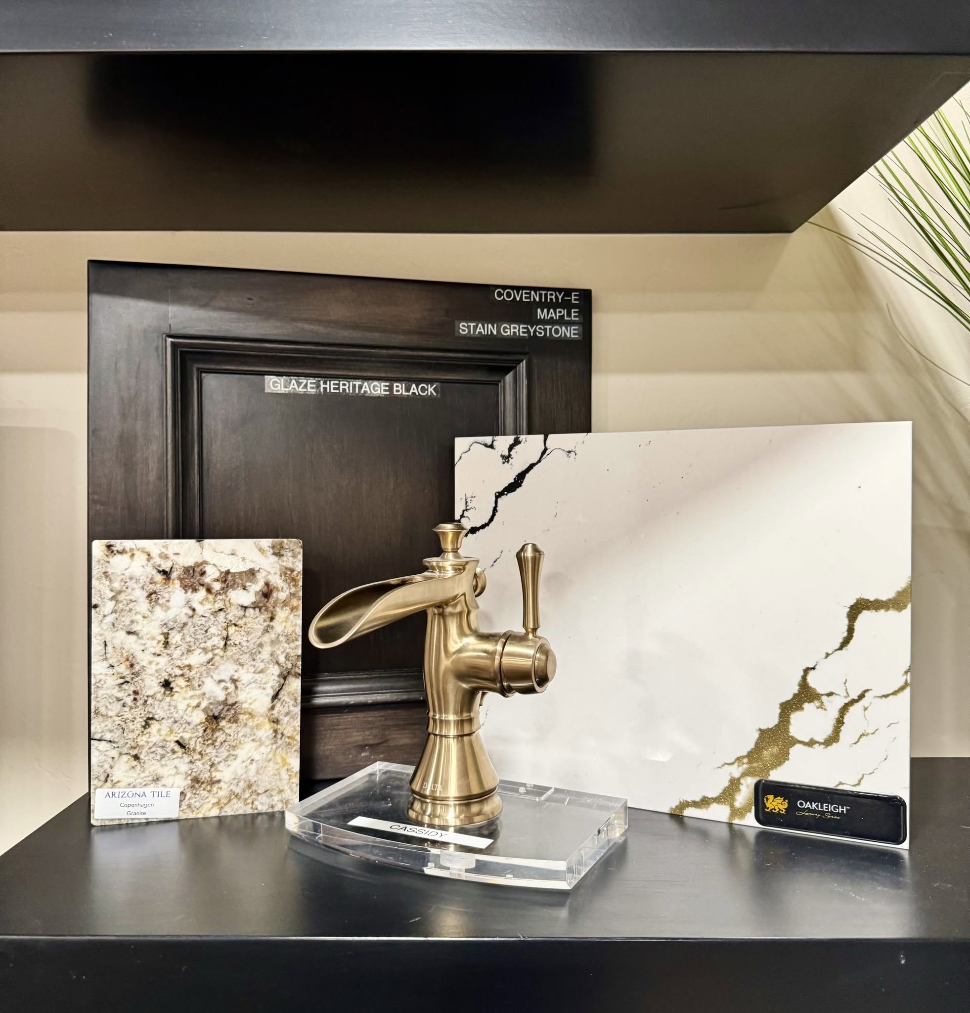 Cabinetry, stone, and brass faucet materials displayed in the Birchard Remodeling showroom